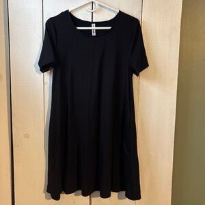 Woman’s plain black short sleeve flowy knee length dress